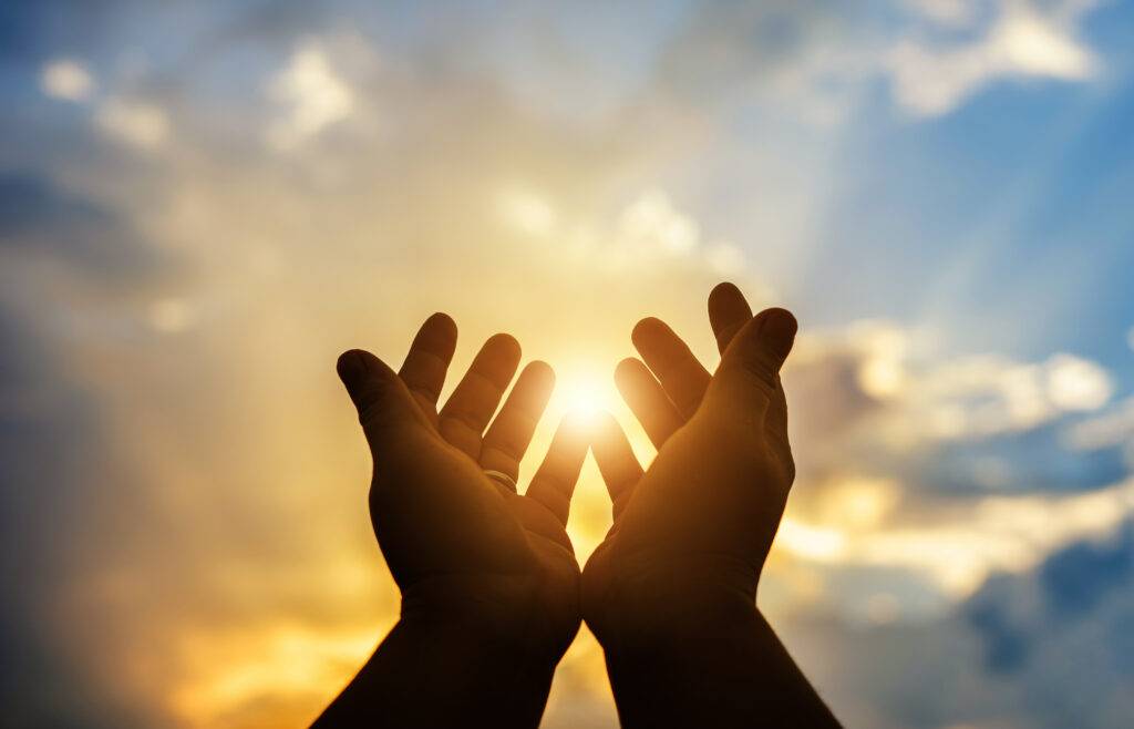 Hands Raised in Prayer or Worship Towards the Sun